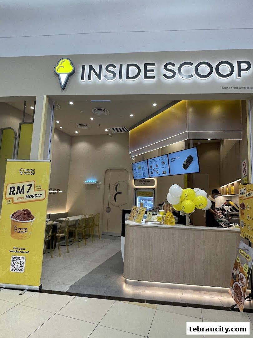 The entrance of an Inside Scoop ice cream shop with a promotional banner and balloons.