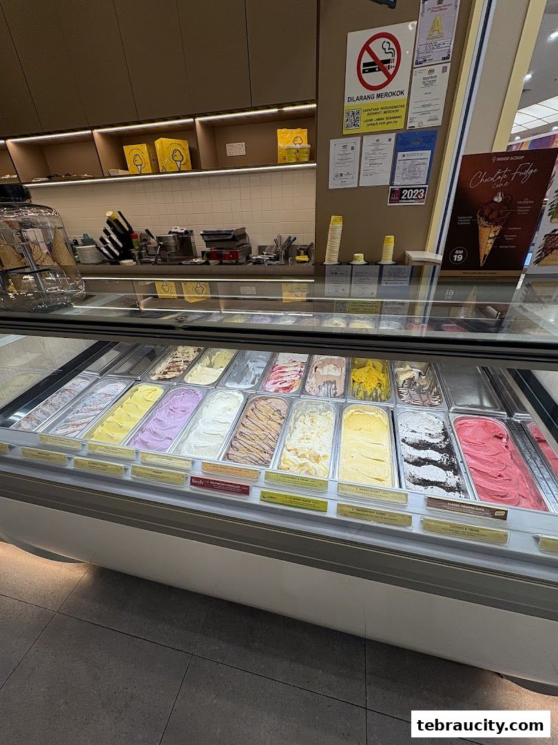 A display case filled with various flavors of ice cream at Inside Scoop.