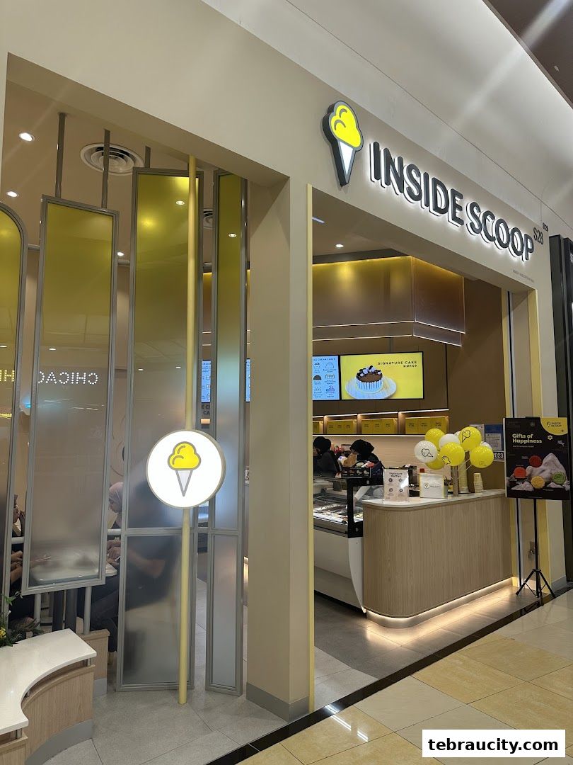 The entrance of an Inside Scoop ice cream shop with a bright yellow and white interior.