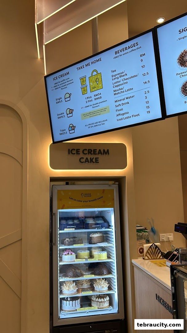 An Inside Scoop ice cream shop with a display of cakes and a digital menu board.