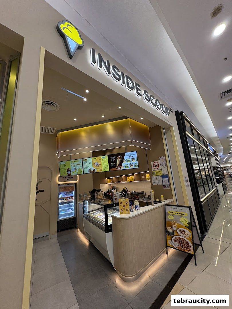 The Inside Scoop ice cream shop with its display freezer, counter, and menu boards.
