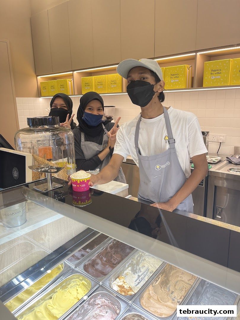 Staff members at an ice cream shop posing for a photo behind the counter.