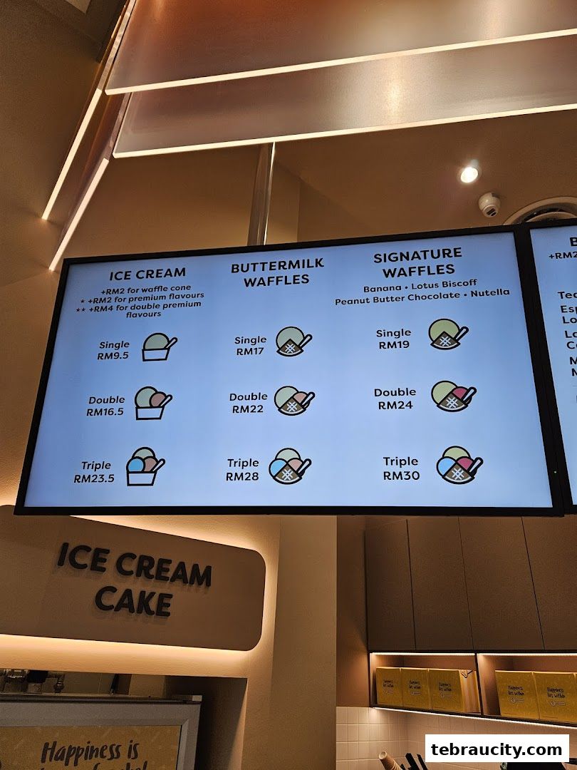 A digital menu board displaying ice cream, buttermilk waffles, and signature waffles with prices.
