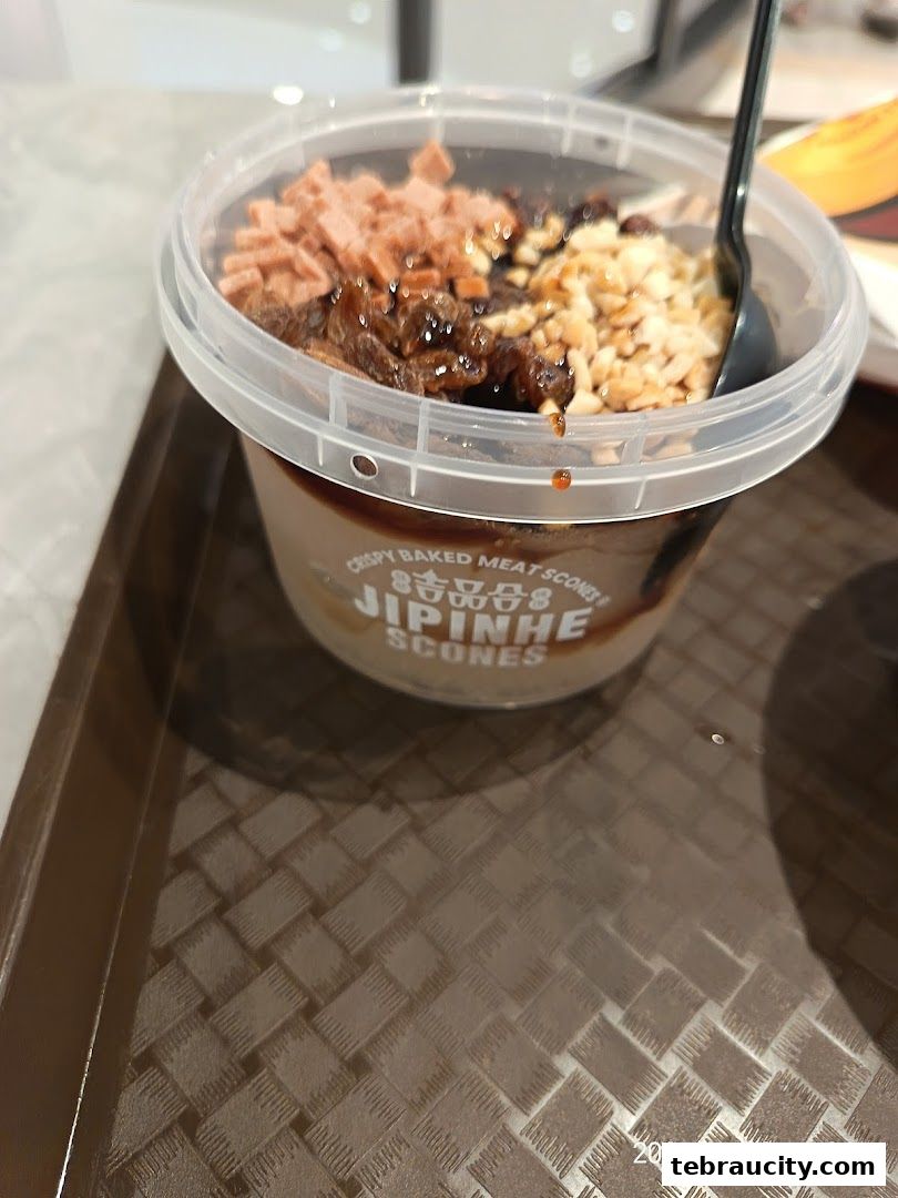 A close-up of a Jipinhe Scones dessert in a clear plastic cup with toppings.