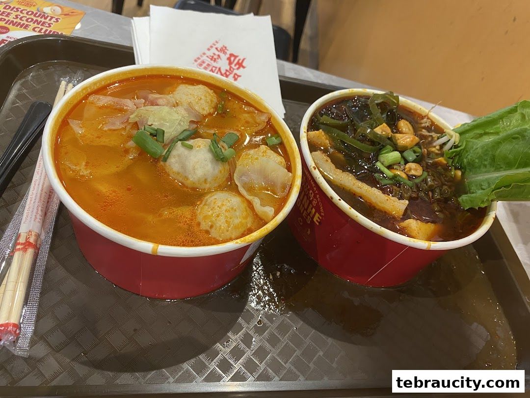 Two bowls of flavorful noodle soup with various toppings and chopsticks on a tray.