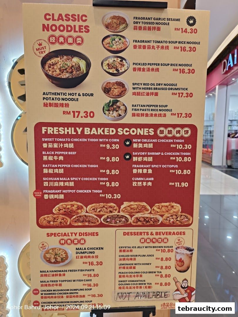 A menu board displaying classic noodles, freshly baked scones, specialty dishes, and desserts.