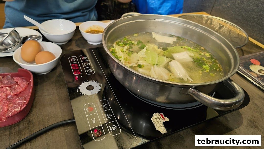 A hot pot with vegetables and broth, served with raw meat and eggs.