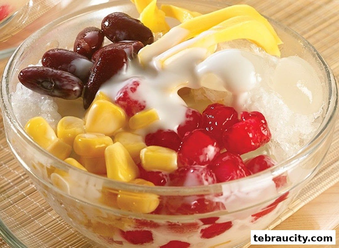 A refreshing dessert bowl filled with shaved ice, corn, red beans, lychee, and mango.