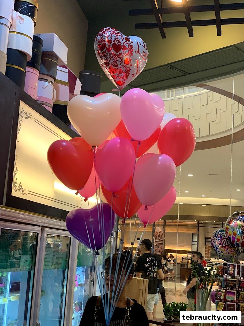 A vibrant display of heart-shaped balloons in various shades of pink, red, and purple.