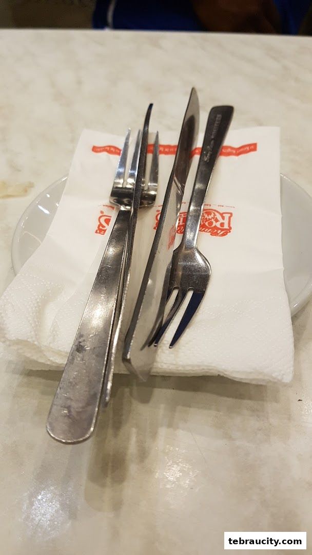 A close-up shot of cutlery and a napkin from Kenny Rogers Roasters.