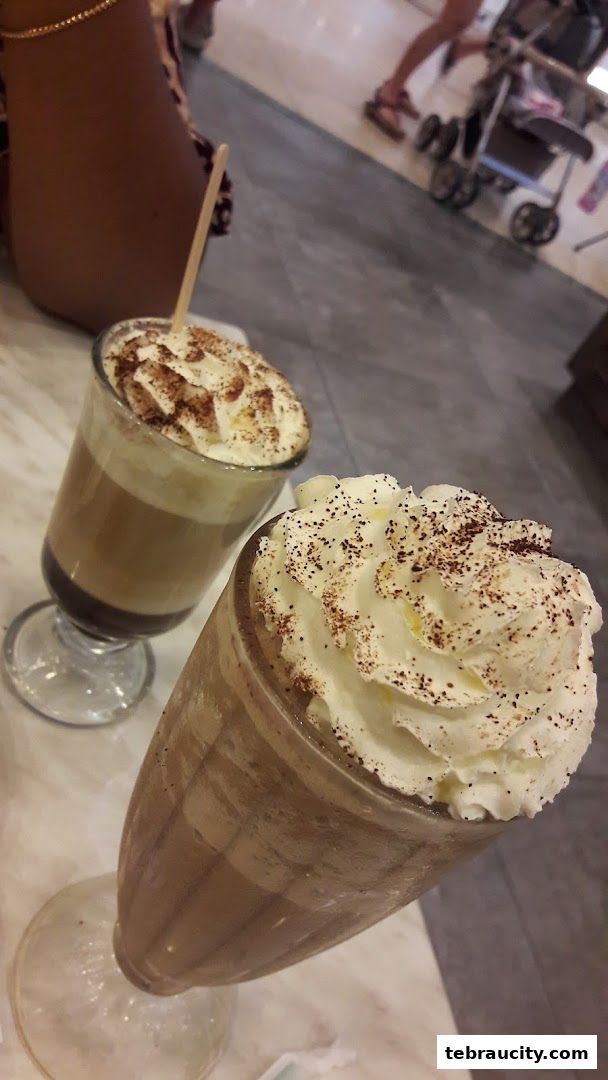 Two delicious drinks topped with whipped cream and chocolate powder.