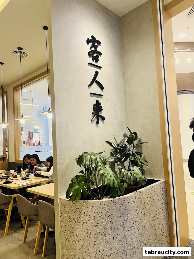 Interior shot of a restaurant with a prominent sign and diners at tables.