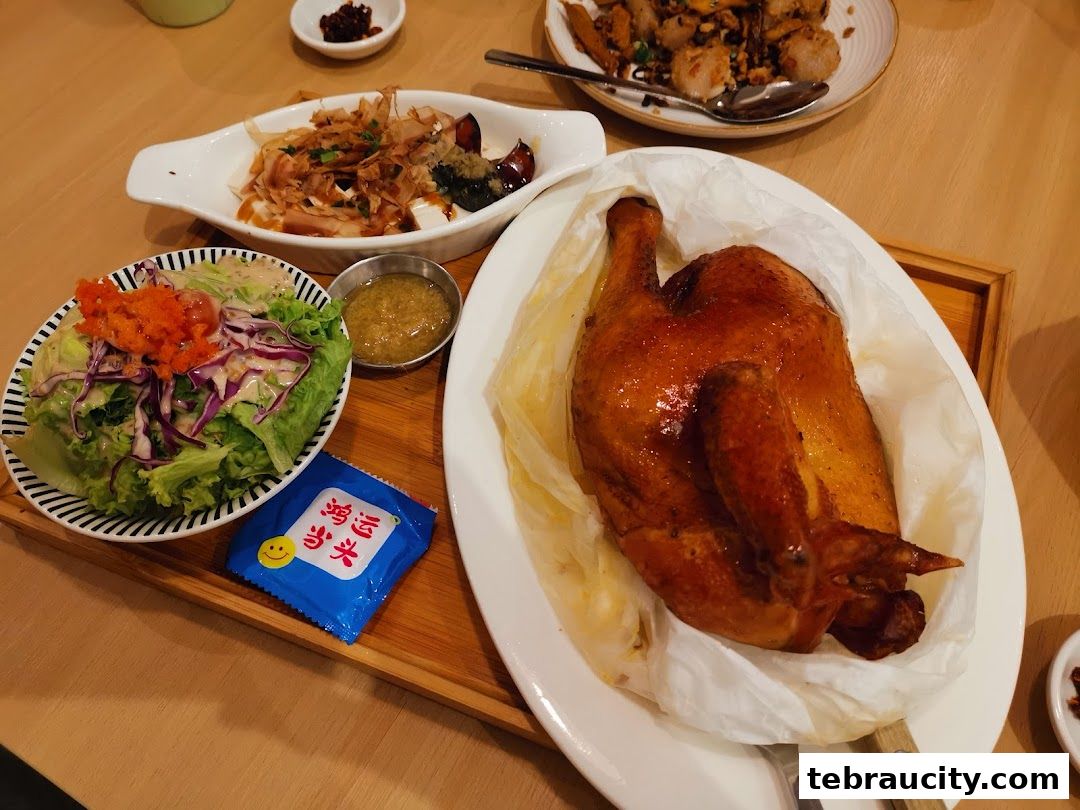 A delicious roasted chicken with a side salad and other dishes on a wooden table.