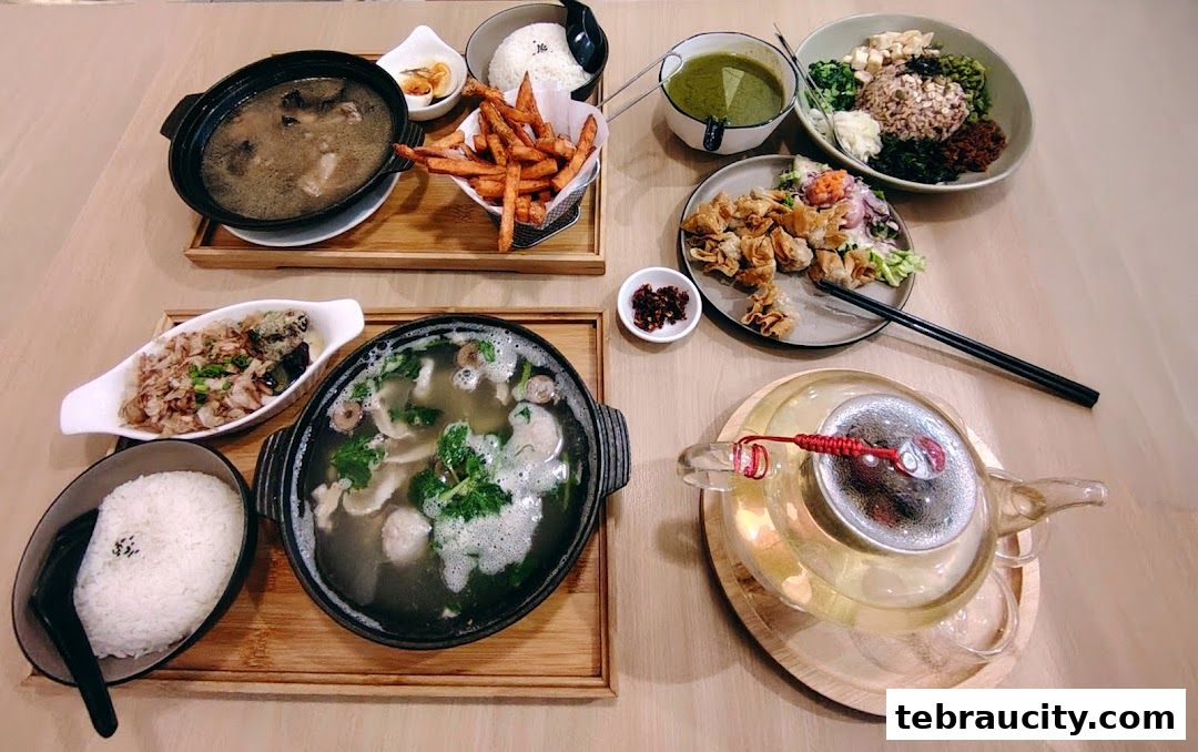 A spread of delicious Asian dishes including soup, rice, fries, dumplings, and tea.
