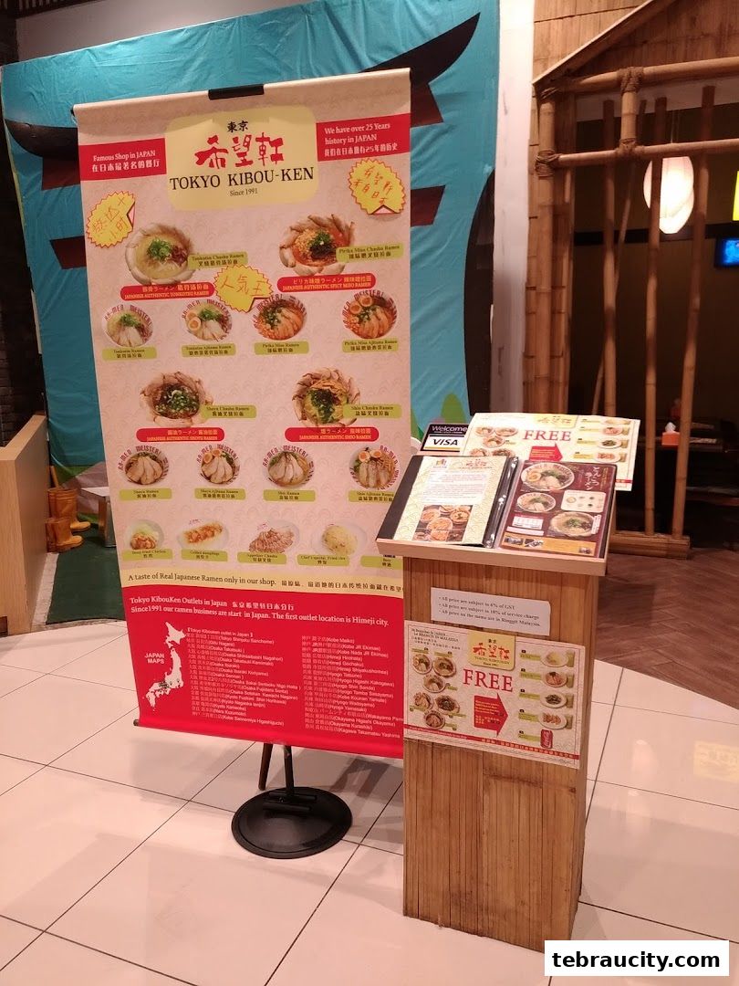 A display board and stand showcasing various ramen dishes and restaurant information for Kibou-ken.