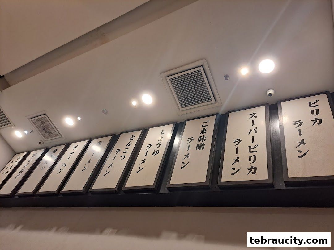 A row of Japanese menu boards displaying different ramen types and other dishes.