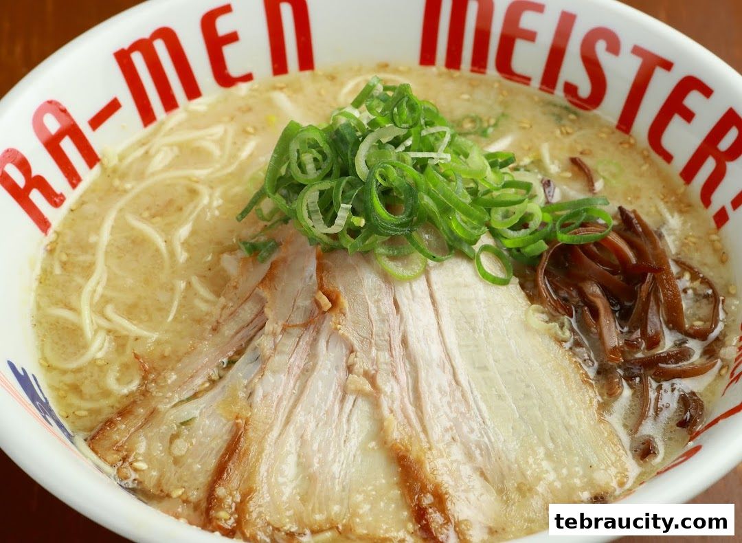 A close-up shot of a delicious bowl of ramen with chashu pork and green onions.