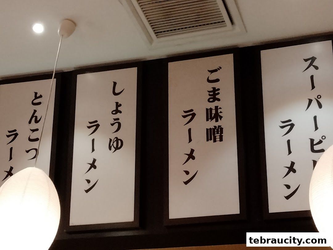 A close-up of a menu board with Japanese ramen dishes displayed.