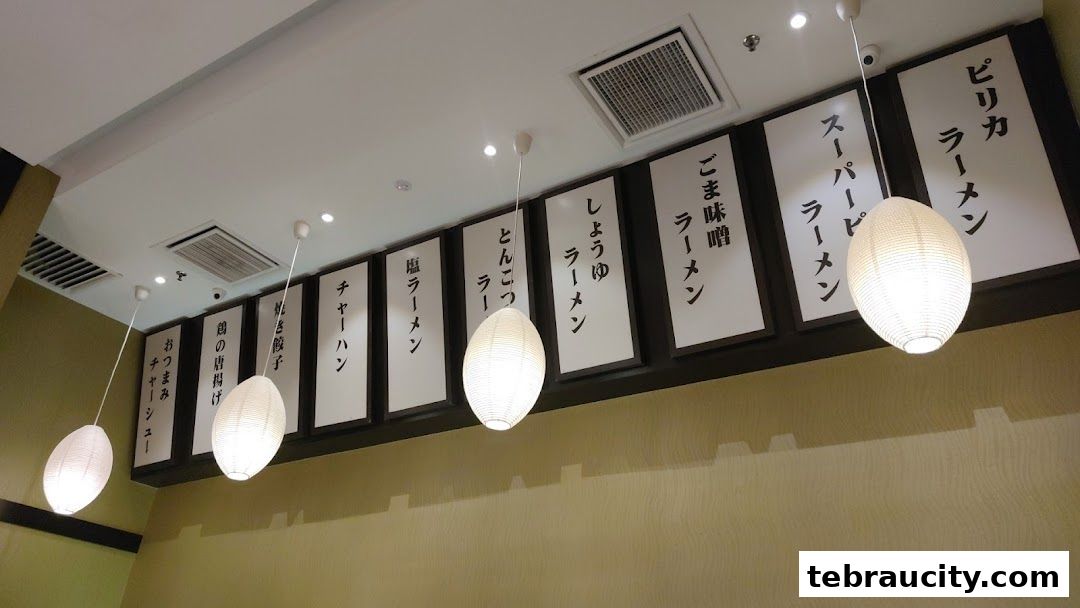 Interior shot of a restaurant with Japanese menu items displayed on the wall.
