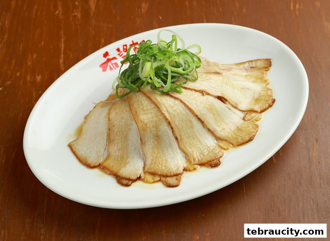 A white oval plate with thinly sliced pork belly topped with green onions.