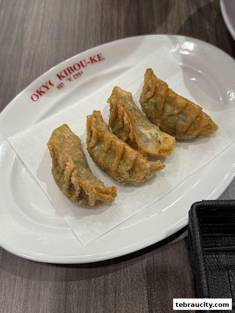 A plate of crispy fried dumplings served on a white plate with the restaurant's logo.