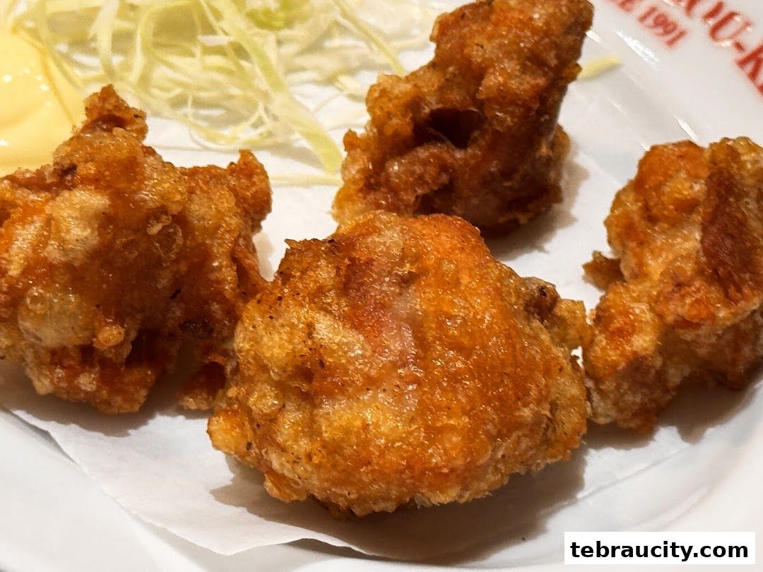 Crispy fried chicken pieces served with shredded cabbage and a side of sauce.
