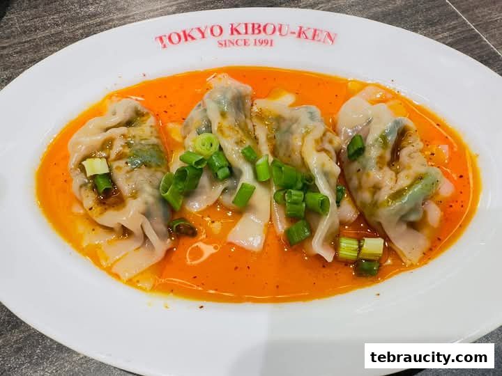 A plate of delicious dumplings in a spicy sauce, garnished with chopped green onions.
