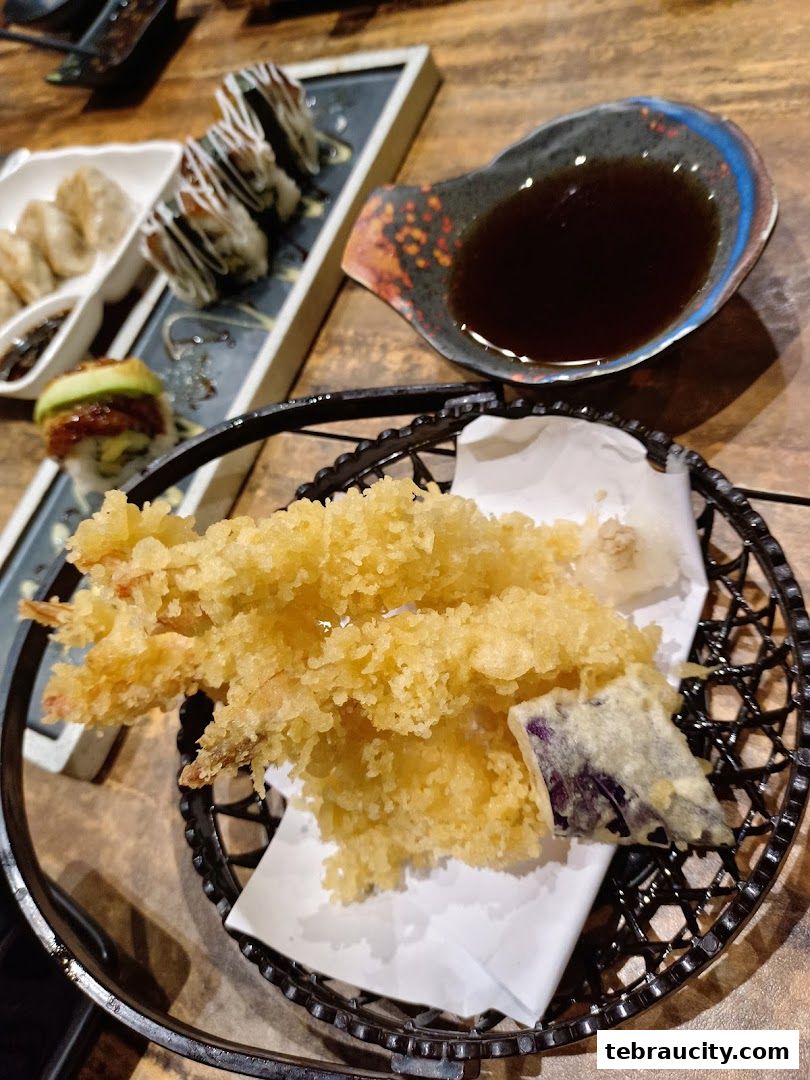 A close-up of delicious Japanese tempura shrimp and vegetables with dipping sauce.