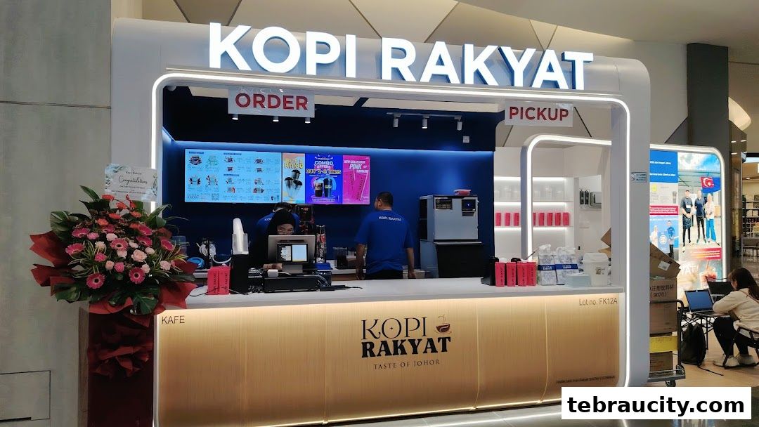 The Kopi Rakyat shop front with staff serving customers and promotional displays.