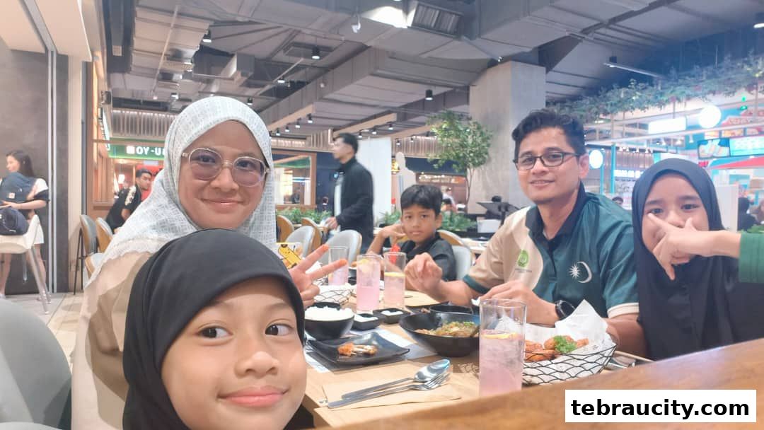 A family enjoys a meal together at a restaurant, smiling for a selfie.