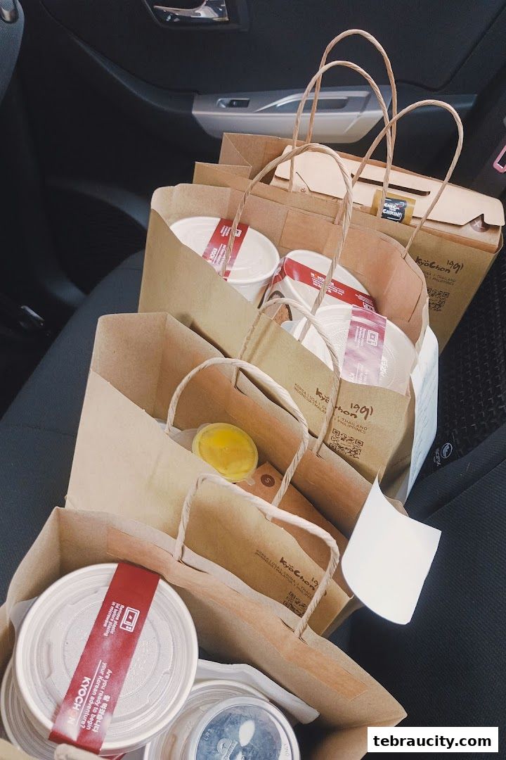 Several paper bags filled with food from KyoChon1991 are neatly arranged.
