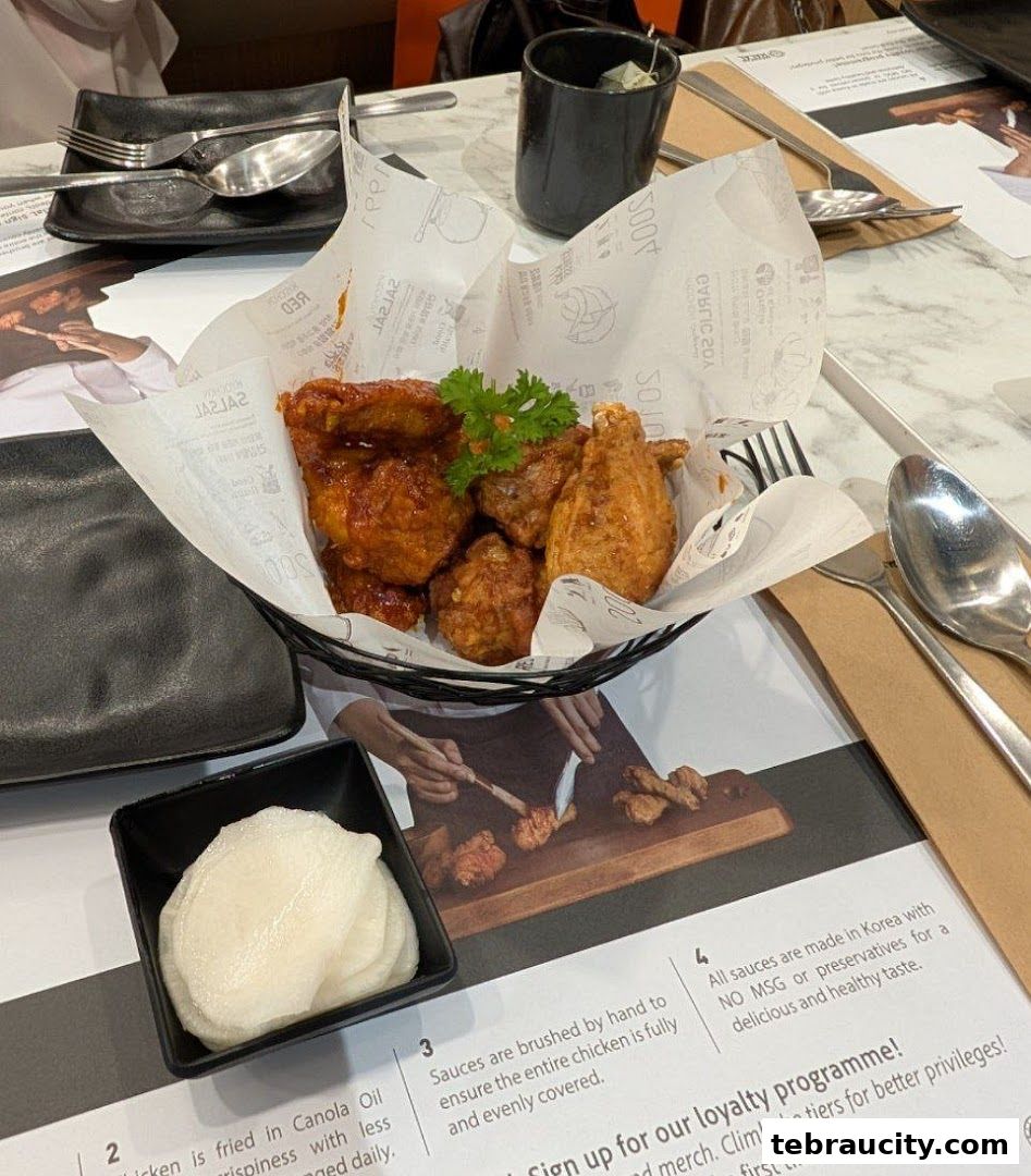 A basket of crispy fried chicken with a side of pickled radish, served at KyoChon1991.