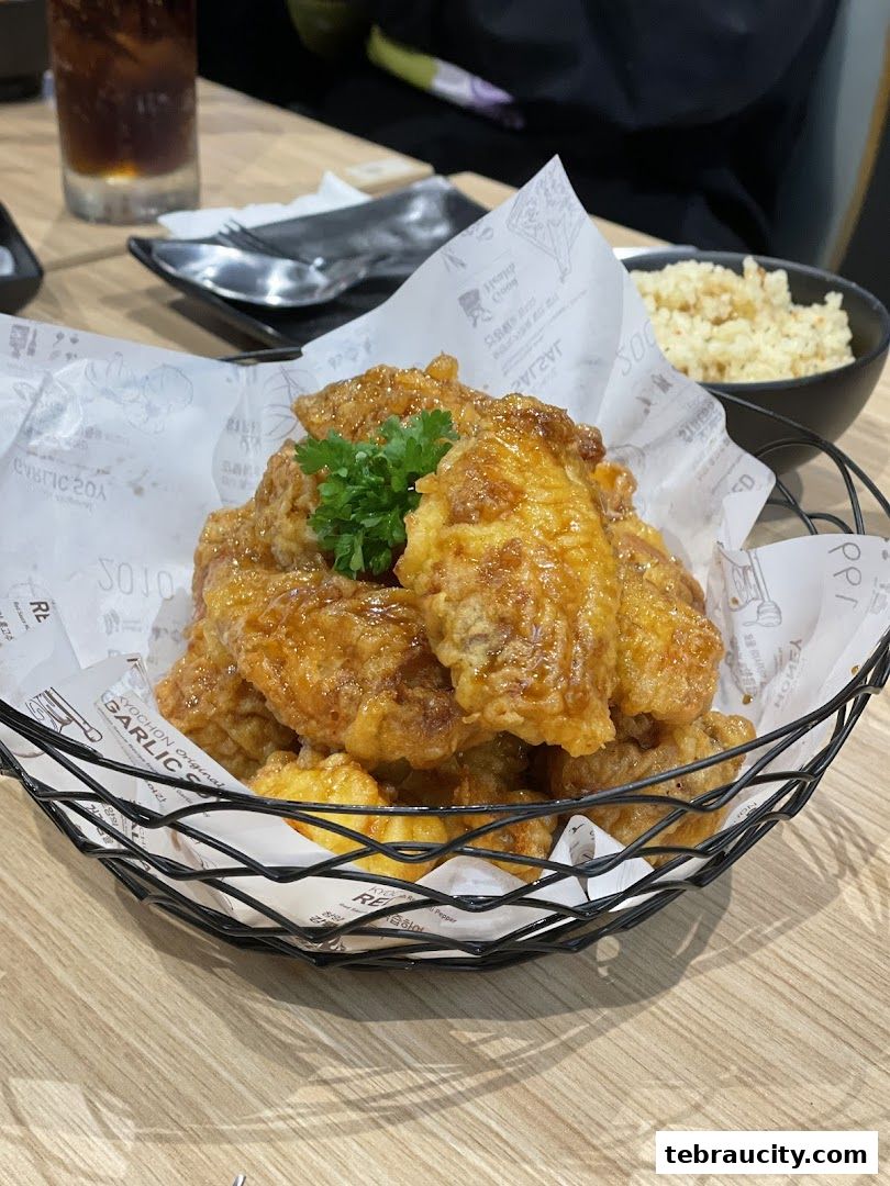 A basket of crispy, glazed Korean fried chicken wings served with a side of rice.