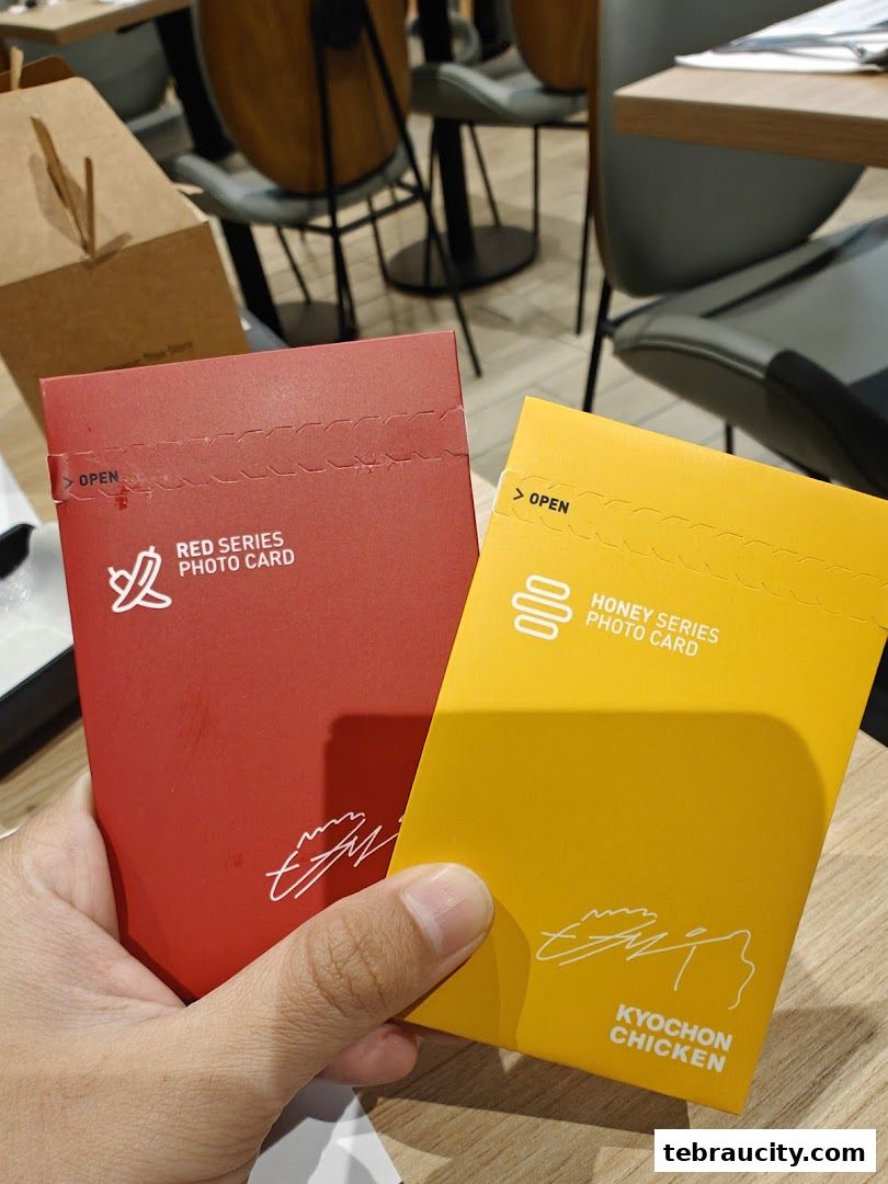 Hands holding KyoChon Chicken photo cards in red and yellow.