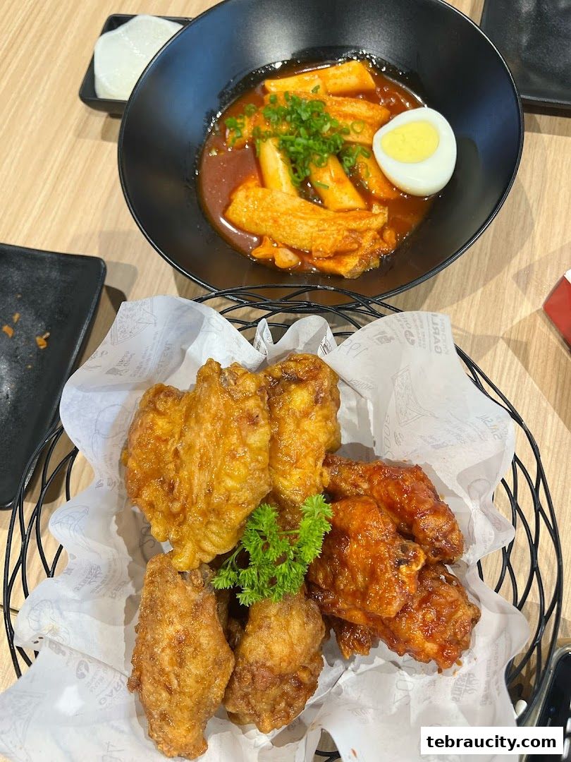 A basket of crispy fried chicken wings and a bowl of tteokbokki with a boiled egg.