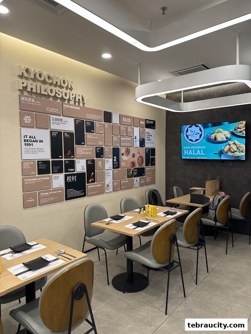 Interior of a KyoChon restaurant with tables set and a display of the company's philosophy.
