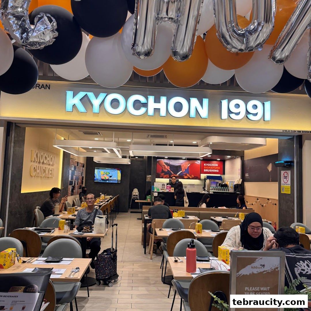The entrance of KyoChon 1991 restaurant with customers seated inside and balloons overhead.