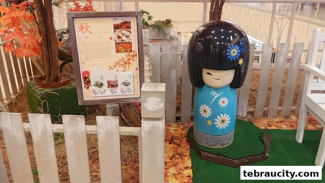 A decorative display featuring a Japanese Kokeshi doll and autumn-themed elements.