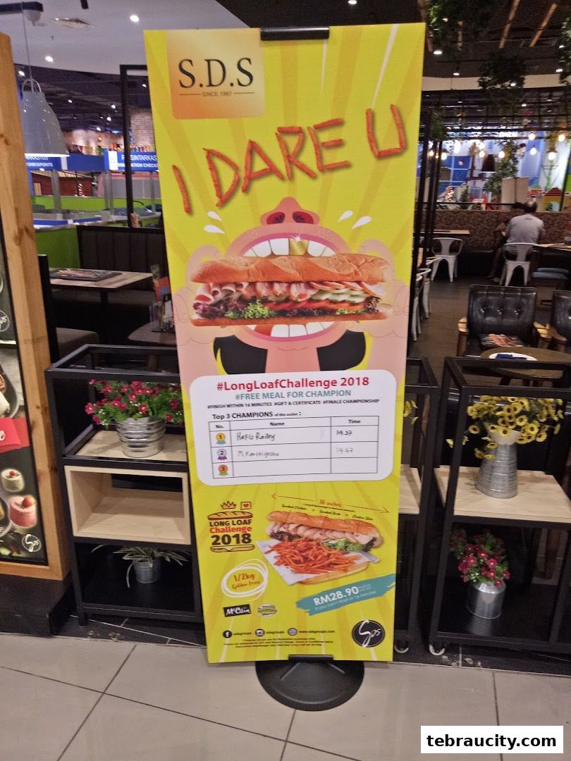 A promotional banner for the SDS Long Loaf Challenge 2018, featuring a large sandwich and fries.