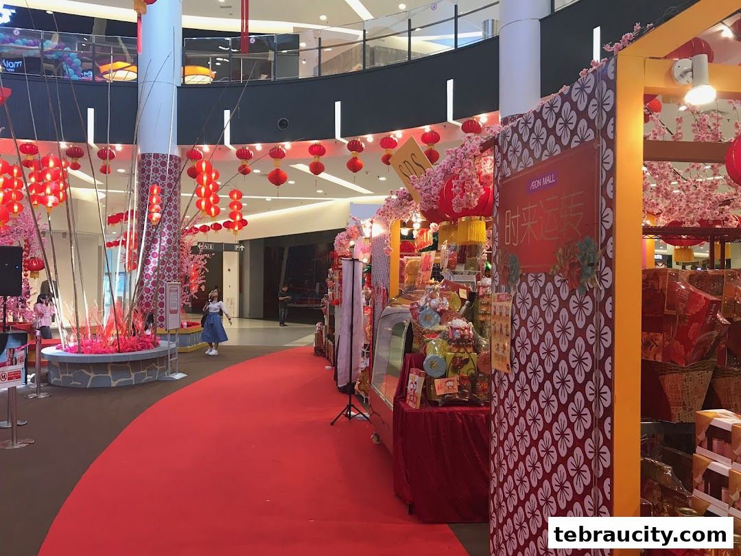A festive display of red lanterns and cherry blossoms in a shopping mall.
