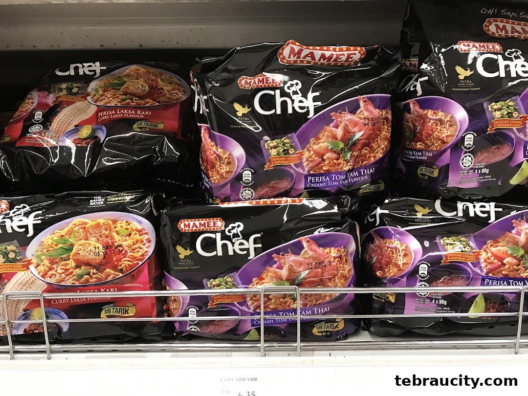 A display of Mamee Chef instant noodle packets in various flavors, including Curry Laksa and Creamy Tom Yam.