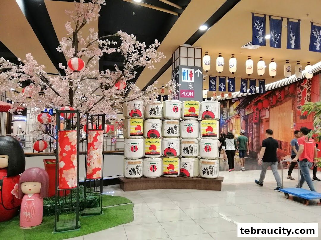 A Japanese-themed display with a cherry blossom tree, lanterns, and decorative barrels.