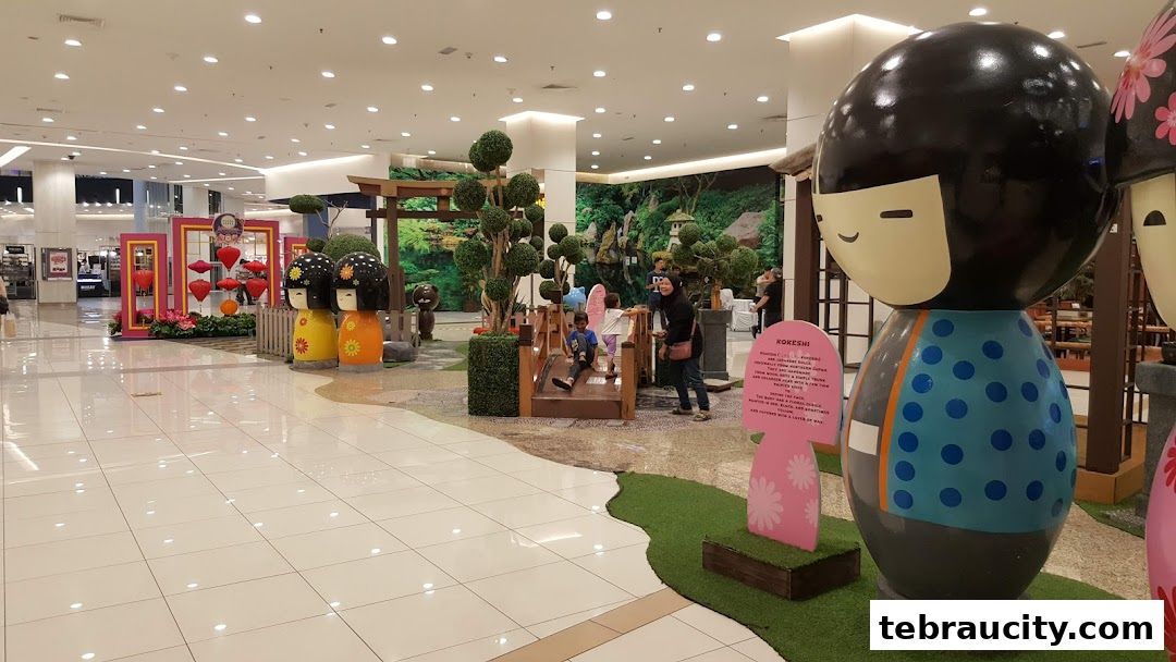 A mall interior decorated with large Kokeshi dolls and a Japanese garden theme.