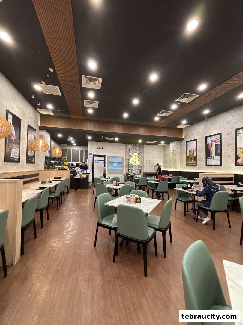 Interior view of a modern restaurant with green chairs and marble-top tables.