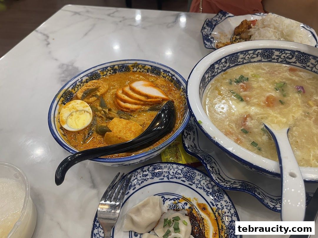 A close-up shot of delicious Asian cuisine, featuring noodles, soup, and dumplings on a marble table.