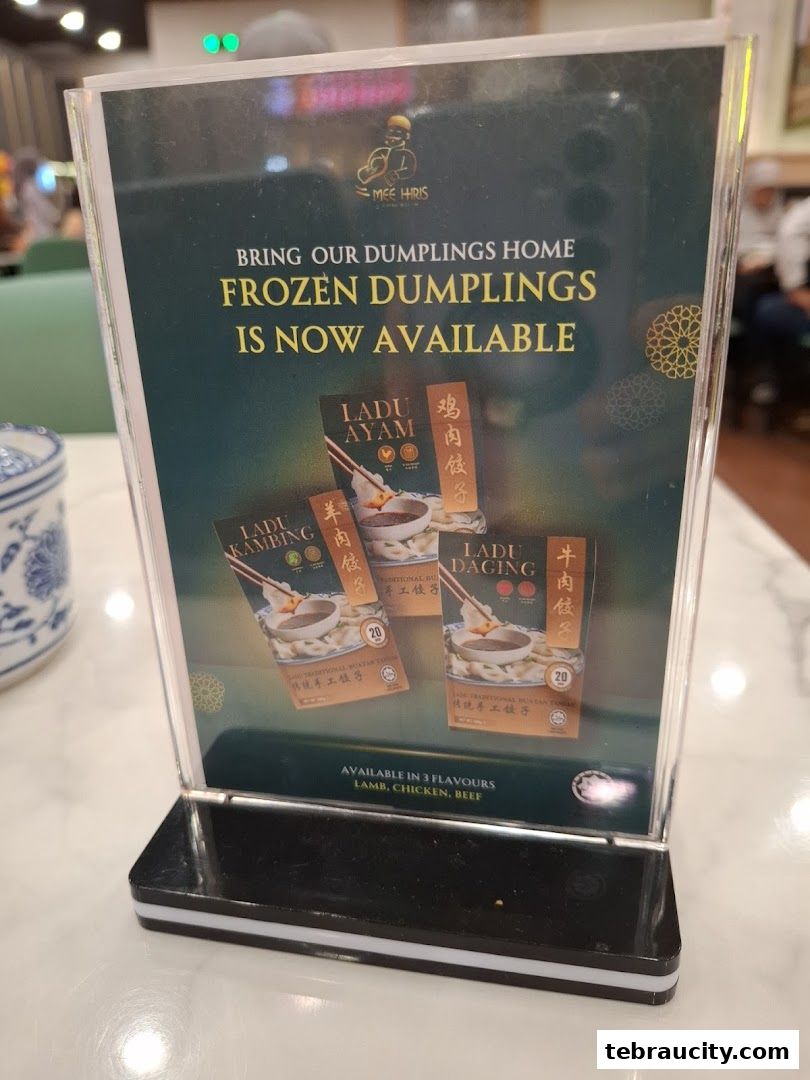 A sign advertising frozen dumplings from Mee Hiris, available in lamb, chicken, and beef flavors.