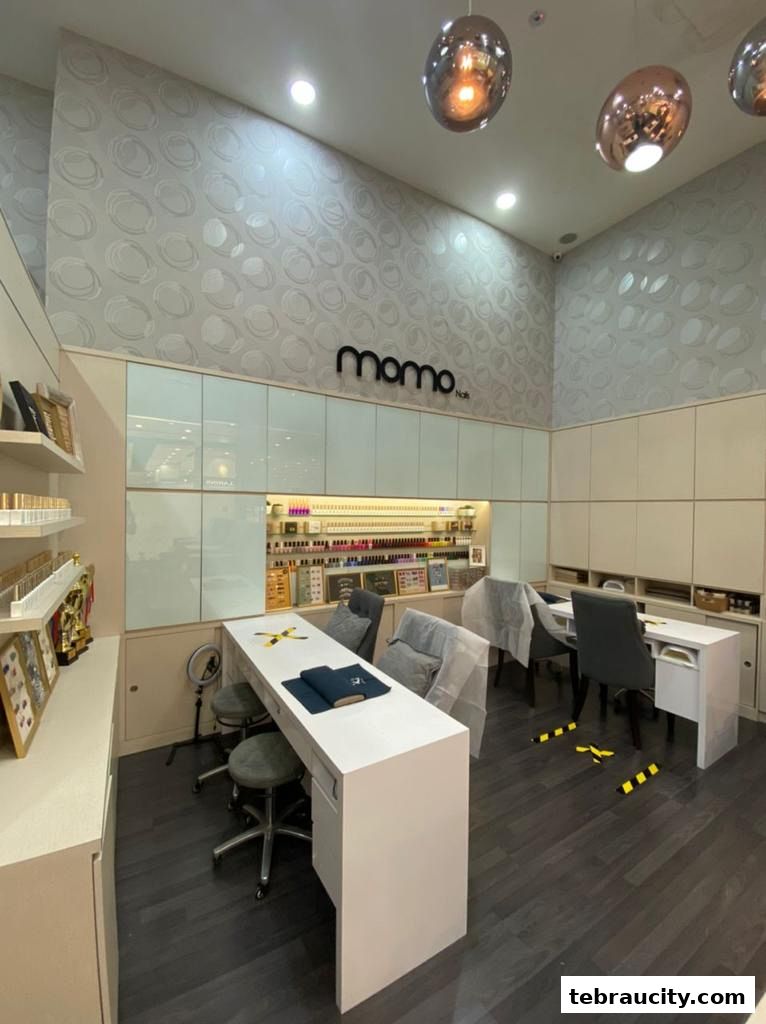 Interior of a modern nail salon with manicure stations and a wide selection of nail polishes.