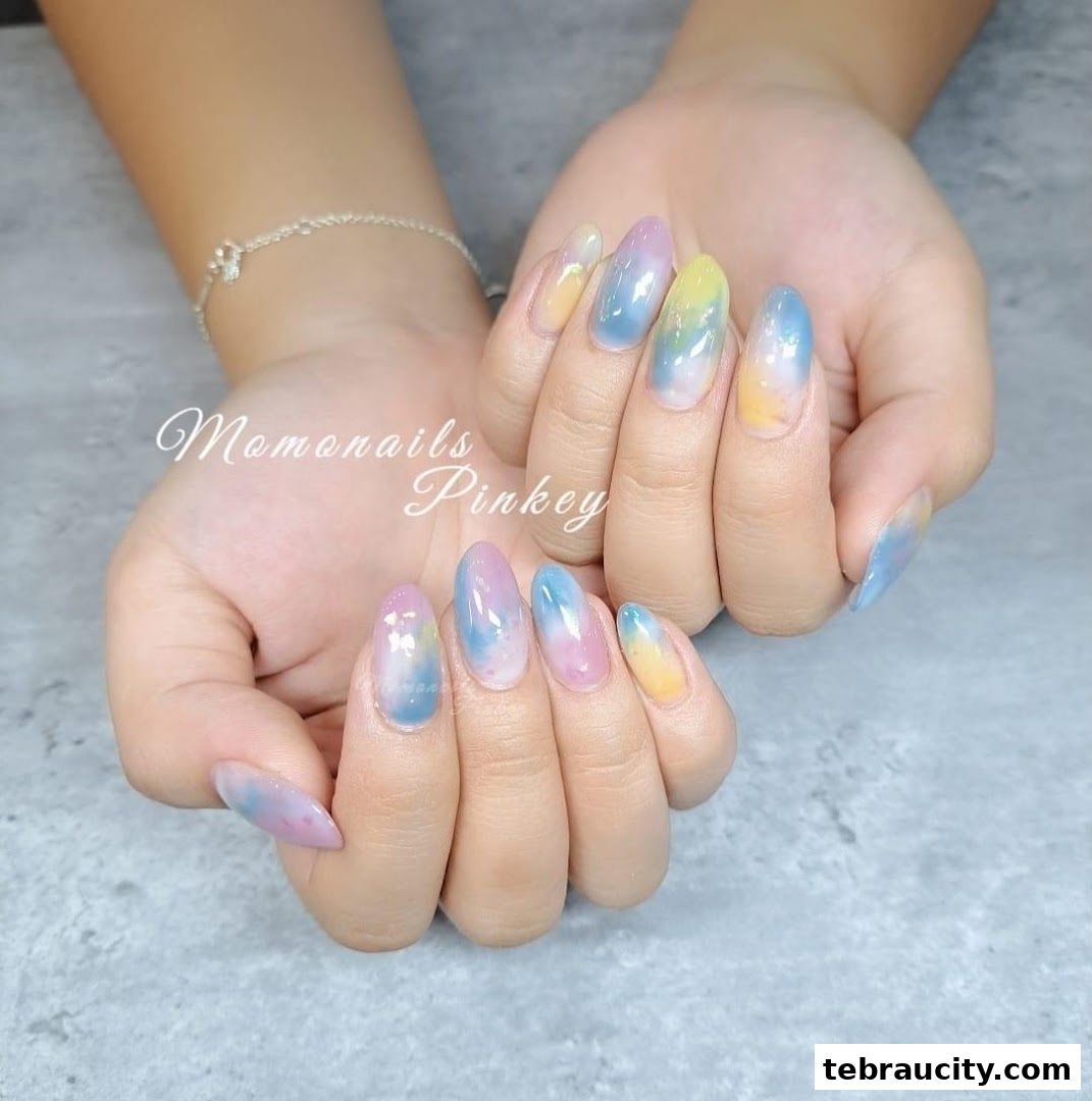A close-up of hands with beautifully designed pastel gradient nails.