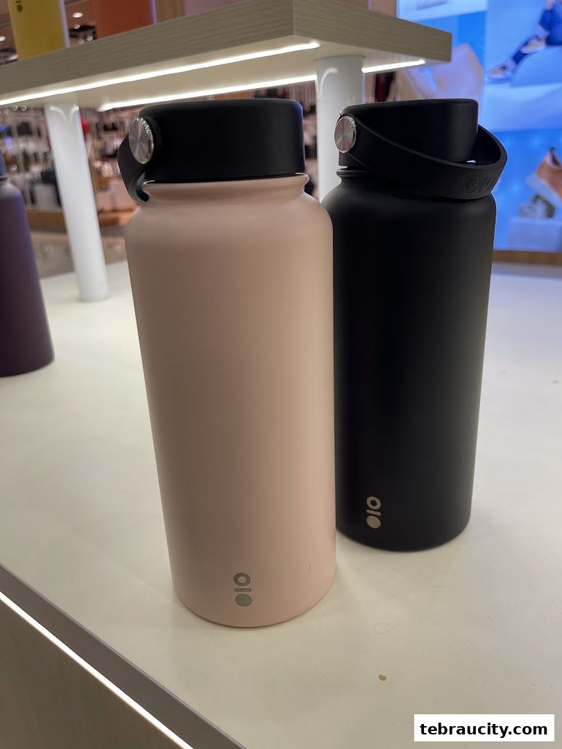 Two Montigo water bottles, one pink and one black, displayed on a shelf.