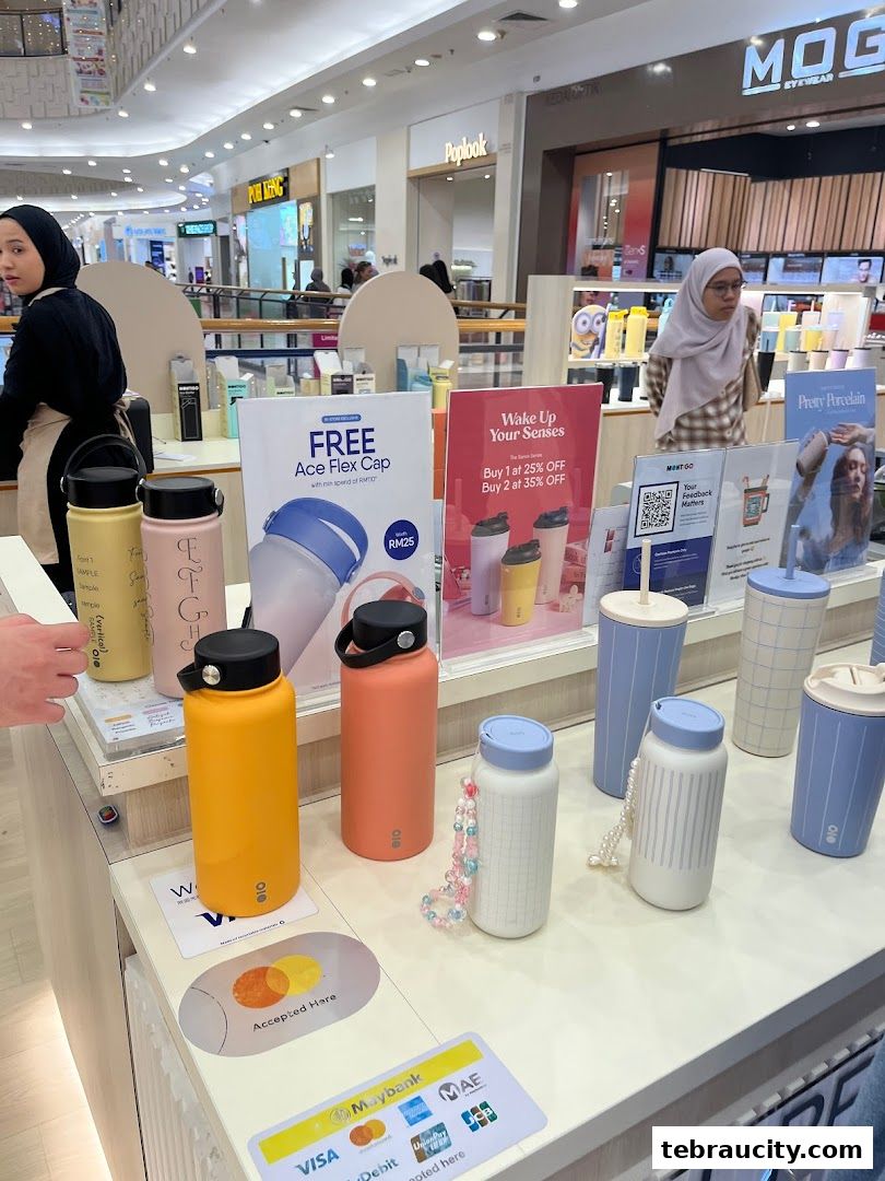 A display of colorful water bottles and tumblers with promotional signs in a retail store.